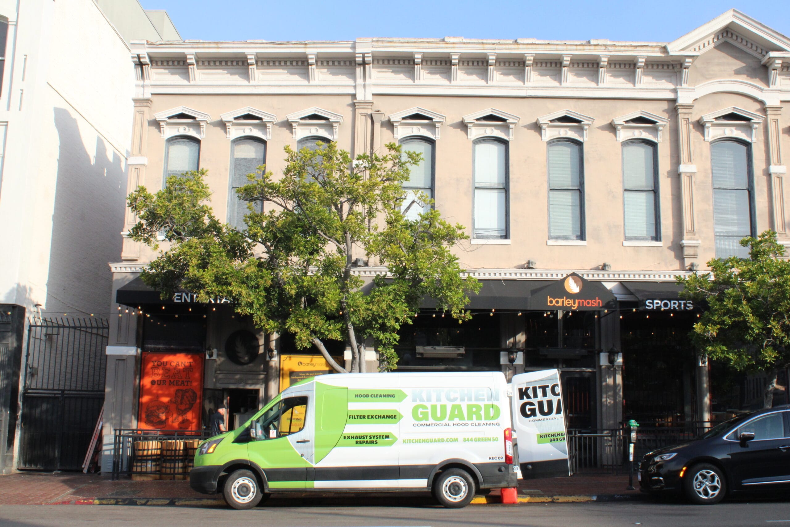 A green van parked along the road in open territory, designated as a kitchen guard for onsite activities.